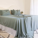 King/Queen bamboo cotton sheet set in eucalyptus green styled on bed