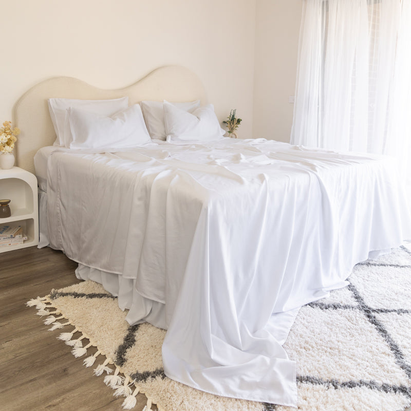 Neatly made bed with white bedding set using 2 separate top sheets