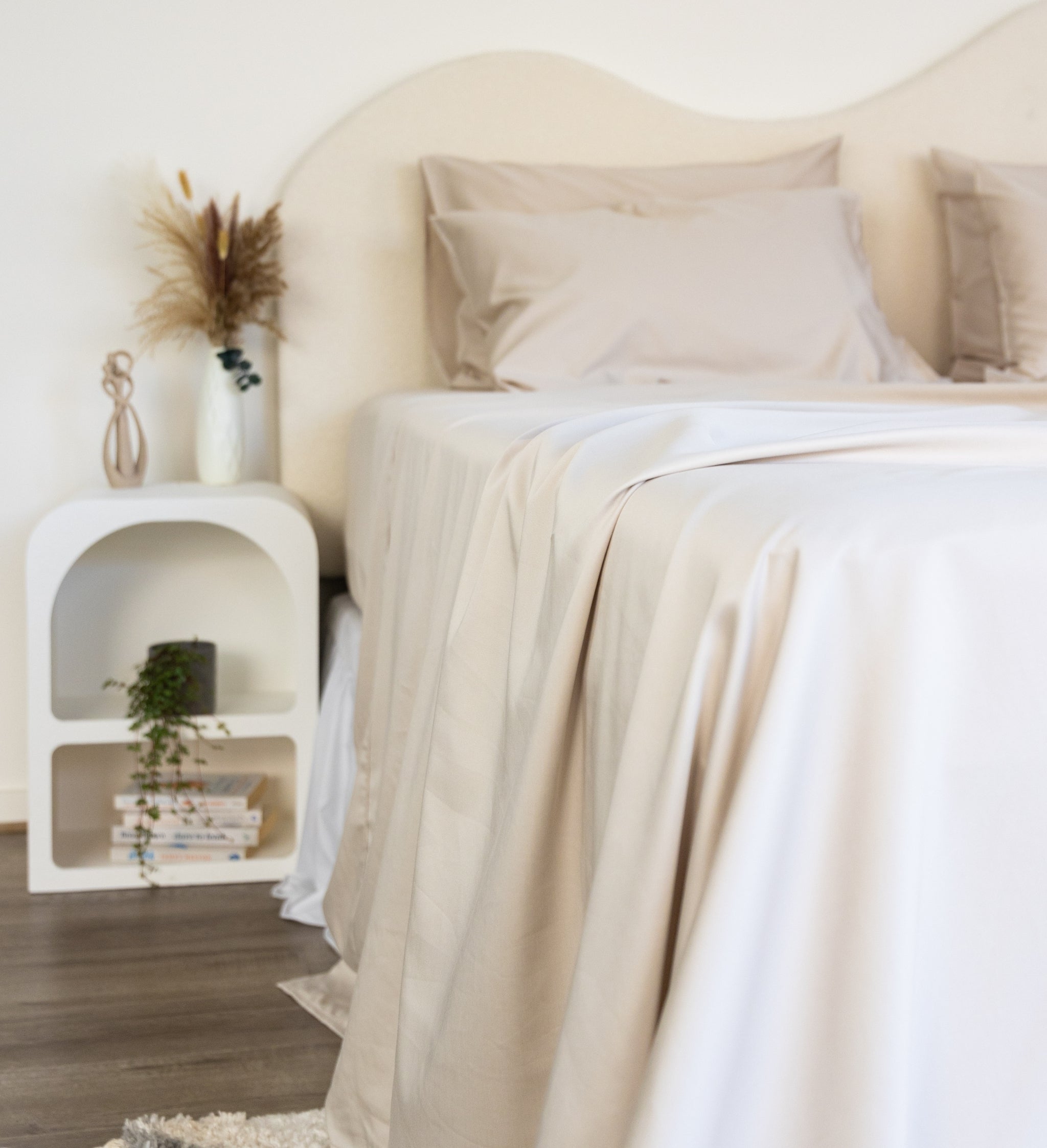 Close up of King/Queen bamboo cotton sheet set in beige styled on bed with nice sidetable
