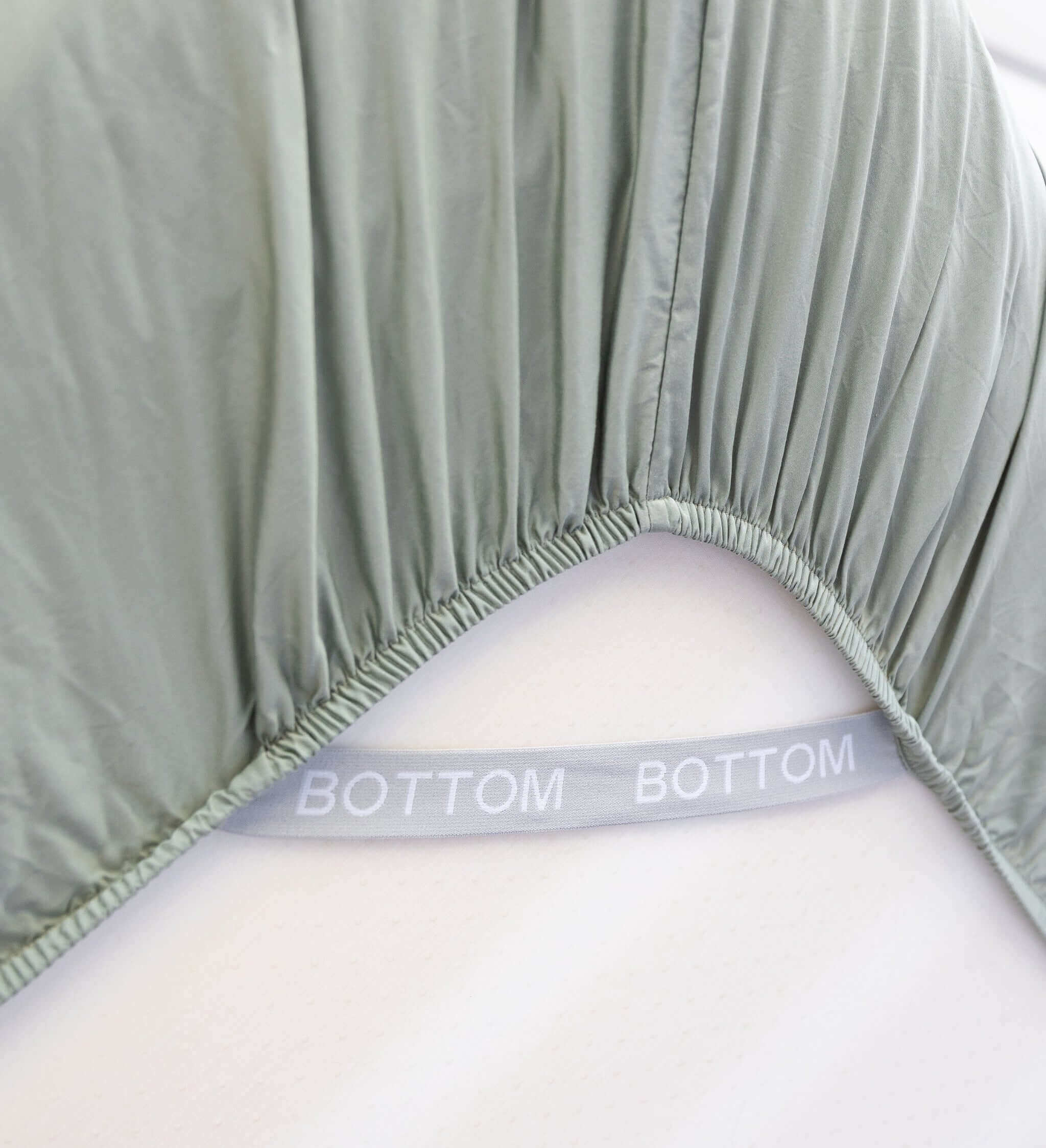 eucalyptus green fitted sheet corner support strap labelled with bottom