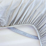 grey sage fitted sheet corner support strap labelled with bottom