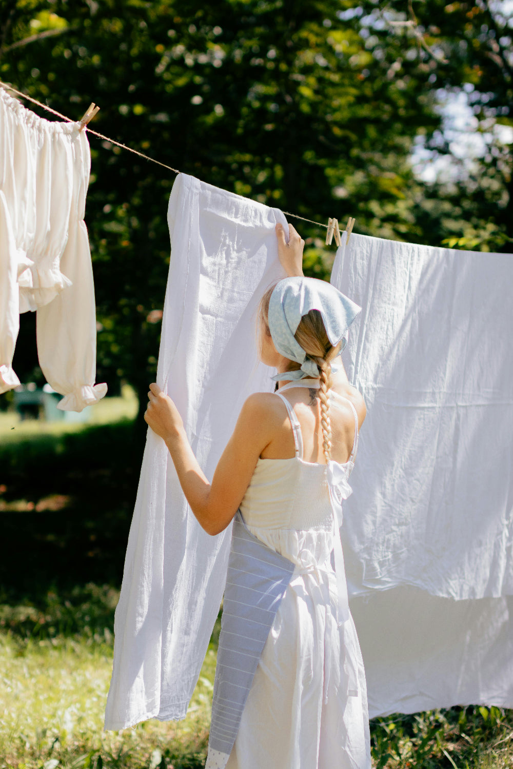 women hanging sheets outside in the shade