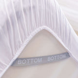 white fitted sheet corner support strap labelled with bottom