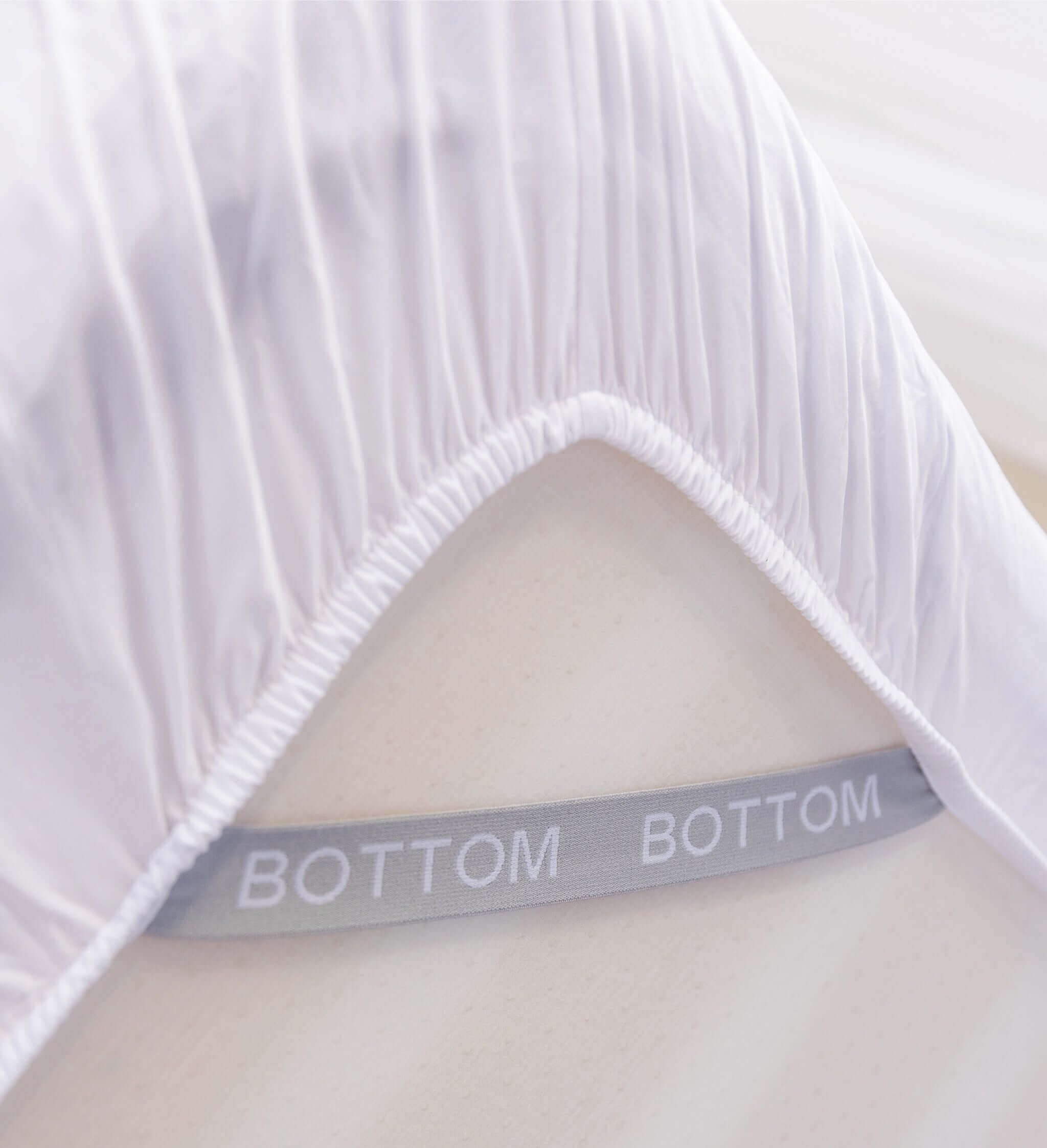 white fitted sheet corner support strap labelled with bottom