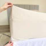hands holding corner of beige fitted sheet showing 46cm pocket depth 