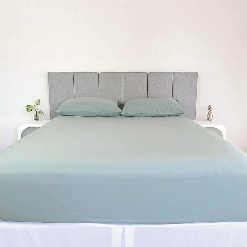 bed styles with eucalyptus green fitted sheet and 2 matching pillows with grey headboard