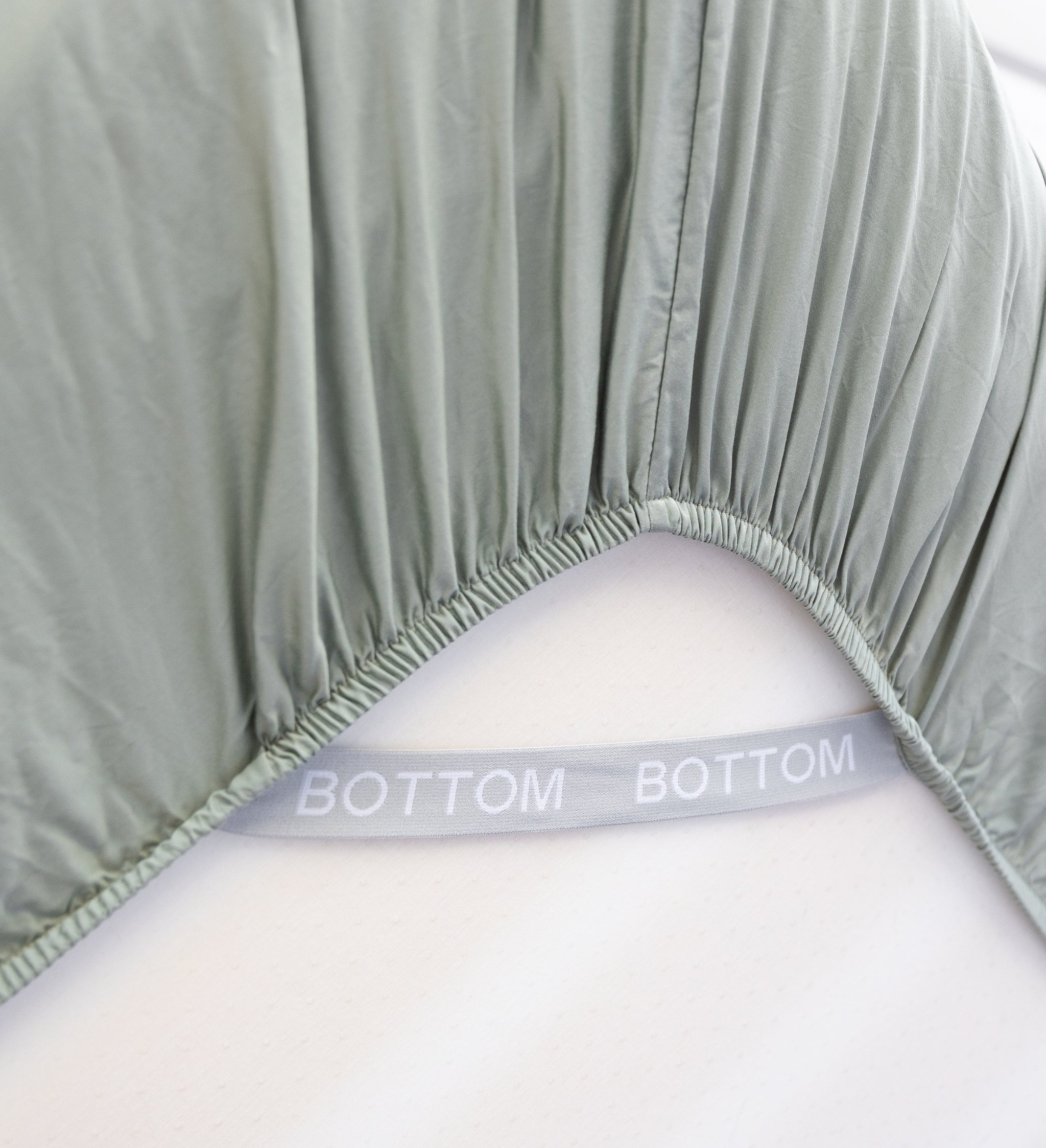 eucalyptus green fitted sheet corner support strap labelled with bottom