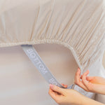beige fitted sheet corner support strap labelled with bottom