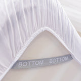 white fitted sheet corner support strap labelled with bottom